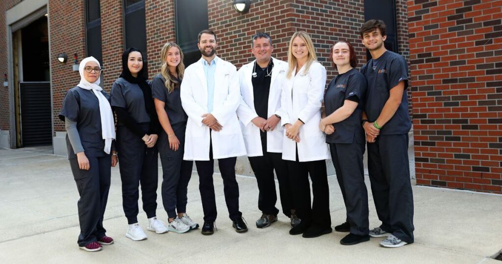 A team of medical scribes from iScribeMD and healthcare providers standing together.